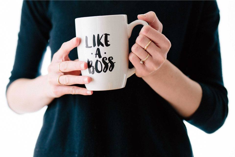 Like a boss. Like one with authority, confident in the right to act, the right to decide, and to guarantee results. Like you've been doing it for years. Like you could do it in your sleep. Photograph of a woman holding a coffee mug with "Like A Boss" printed on it.