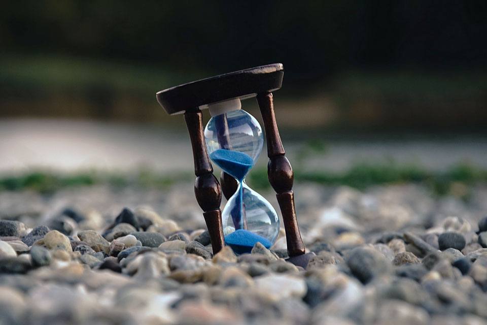 The journey of a thousand miles begins with the first step. Time waits for no-one, and patience is the key to happiness and success. Photograph of an hourglass. 
